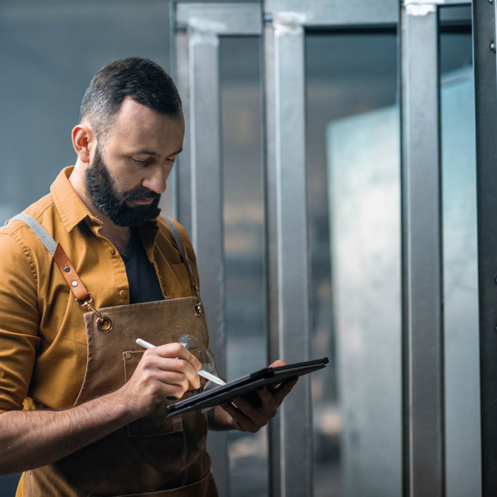 Engineer or factory worker using digital technology in the production of metal products, using a digital tablet at the plant. High quality photo